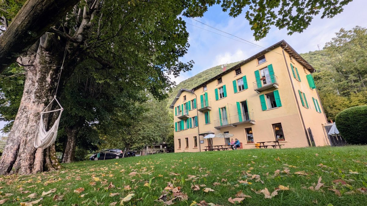 The Montino house with green shutters, seen across the garden under a big chestnut tree